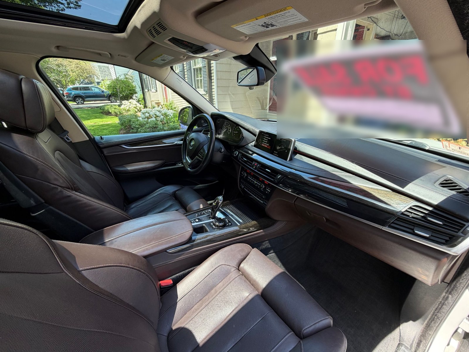 Front seats and dashboard from the passenger side, panoramic roof open